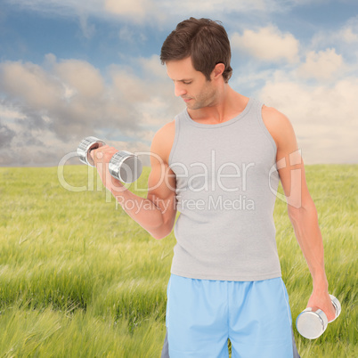 Composite image of fit young man exercising with dumbbells