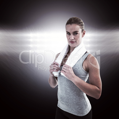 Composite image of muscular woman holding a towel around her nec