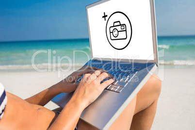 Composite image of woman using laptop on deck chair