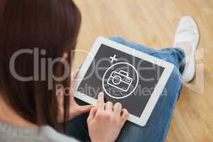 Composite image of girl using a tablet pc sitting on the floor