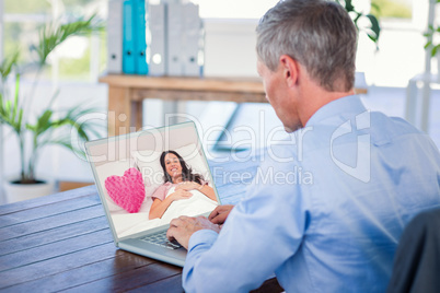 Composite image of woman lying in her bed next to a pink heart p