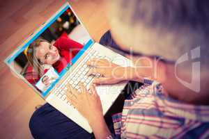 Composite image of man using laptop while sitting on floor at ho
