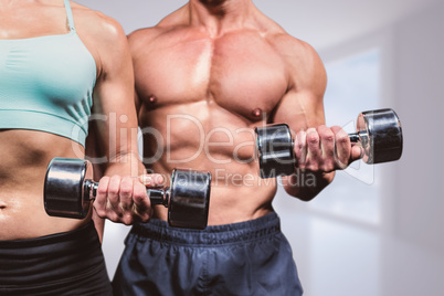Composite image of midsection of woman and man exercising with d