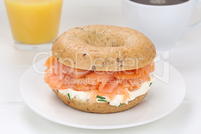 Bagel Brötchen zum Frühstück mit Lachs Fisch, Kaffee und Oran