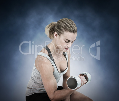 Composite image of  muscular woman working out with dumbbells