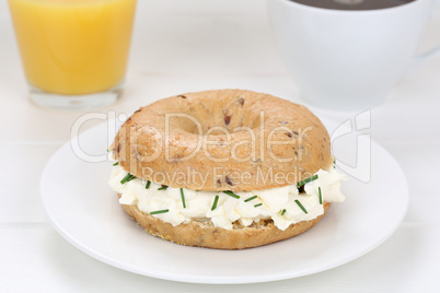 Bagel Brötchen zum Frühstück mit Frischkäse, Kaffee und Oran