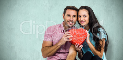 Composite image of happy couple with heart