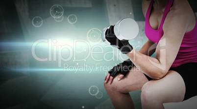 Composite image of muscular woman exercising with dumbbells