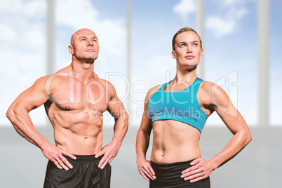 Composite image of muscular man and woman with hand on hip