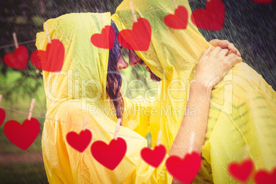 Composite image of couple hugging in the rain