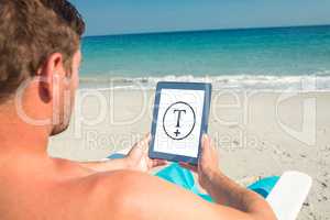 Composite image of man using digital tablet on deck chair at the