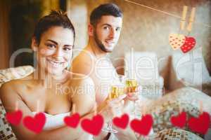 Composite image of happy couple celebrating with champagne