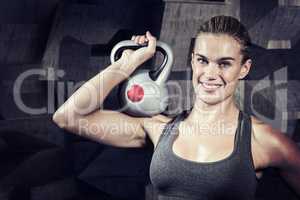 Composite image of muscular woman swinging heavy kettlebell