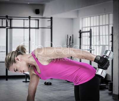 Composite image of muscular woman exercising with dumbbells