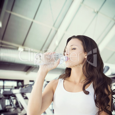 Composite image of brunette drinking water