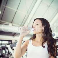Composite image of brunette drinking water
