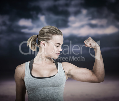 Composite image of serious muscular woman flexing muscle