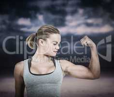 Composite image of serious muscular woman flexing muscle