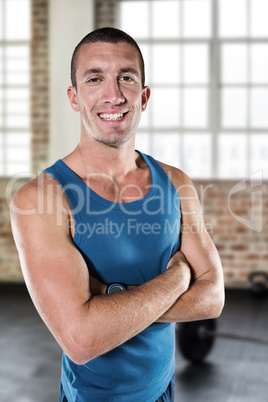 Composite image of smiling athlete with arms crossed