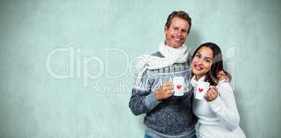 Composite image of festive couple smiling and holding mugs