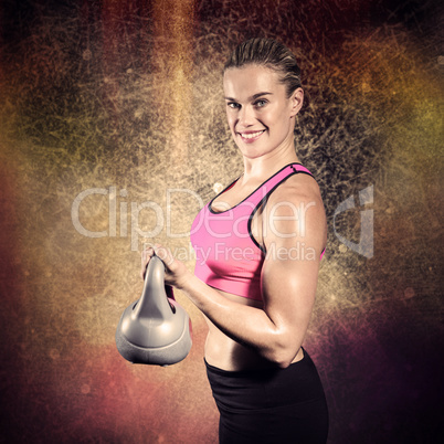 Composite image of muscular woman lifting heavy kettlebell