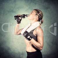 Composite image of muscular woman drinking water