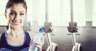 Composite image of fit brunette holding water bottle