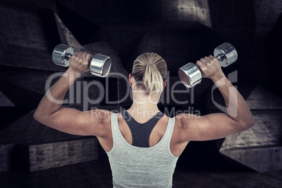 Composite image of  muscular woman working out with dumbbells