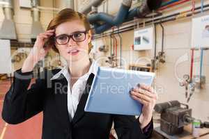 Composite image of redhead businesswoman using her tablet pc