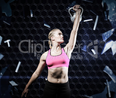 Composite image of muscular woman lifting heavy kettlebell