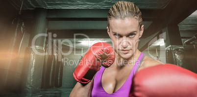 Composite image of portrait of female boxer with fighting stance