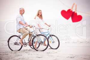 Composite image of happy couple cycling together