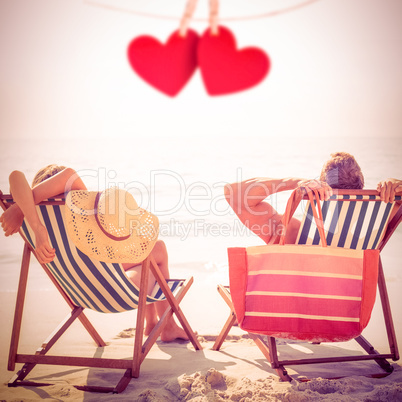 Composite image of couple relaxing on the beach