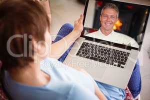 Composite image of pregnant woman using her laptop