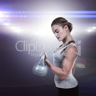 Composite image of serious muscular woman lifting kettlebell