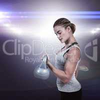 Composite image of serious muscular woman lifting kettlebell