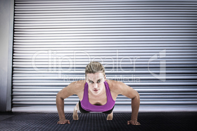 Composite image of muscular woman doing push ups