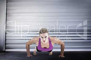 Composite image of muscular woman doing push ups