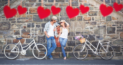 Composite image of attractive couple standing with bikes