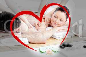 Composite image of relaxing young couple enjoying a back massage