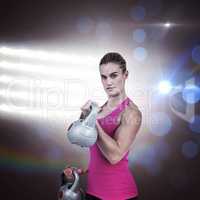 Composite image of muscular woman exercising with kettlebells