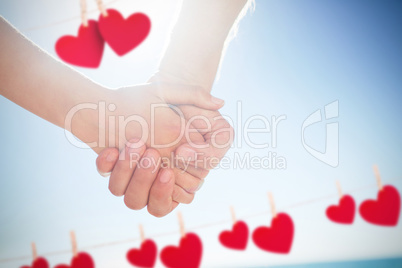 Composite image of couple walking hand in hand