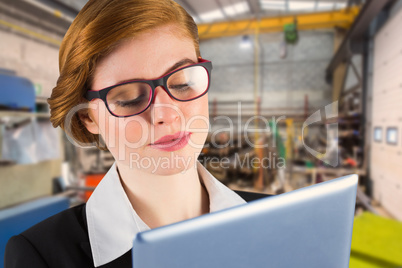 Composite image of redhead businesswoman using her tablet pc