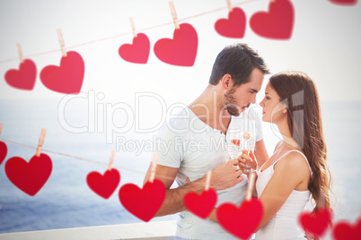 Composite image of cute couple toasting with champagne