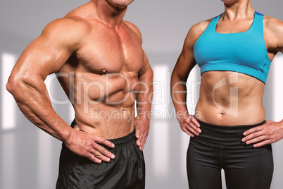 Composite image of midsection of muscular man and woman with han