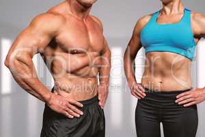 Composite image of midsection of muscular man and woman with han