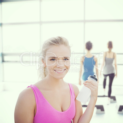 Composite image of smiling healthy woman with water bottle