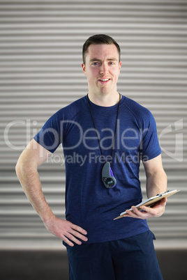 Composite image of attentive trainer writing on his clipboard