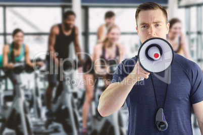 Composite image of male trainer yelling through the megaphone