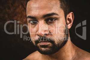 Composite image of muscular man frowning at camera